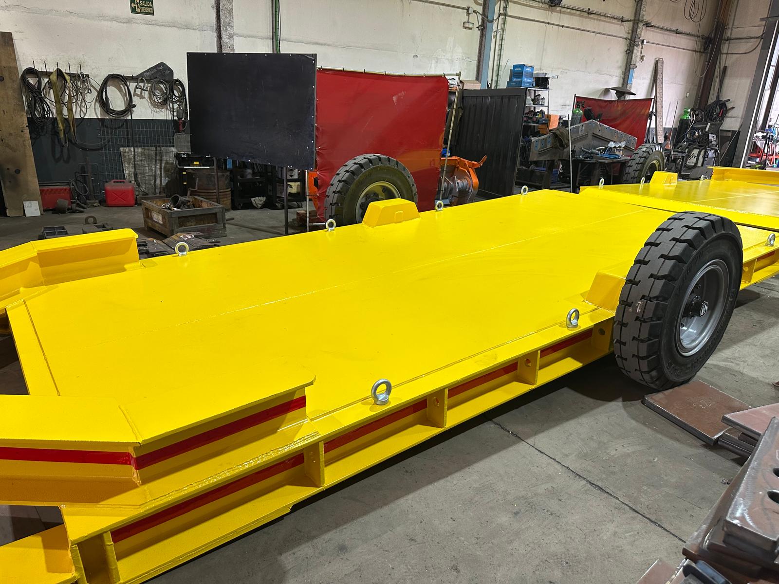 Remolque de transporte minero terminado y pintado de amarillo, con cáncamos de izado, en el taller de Indutech