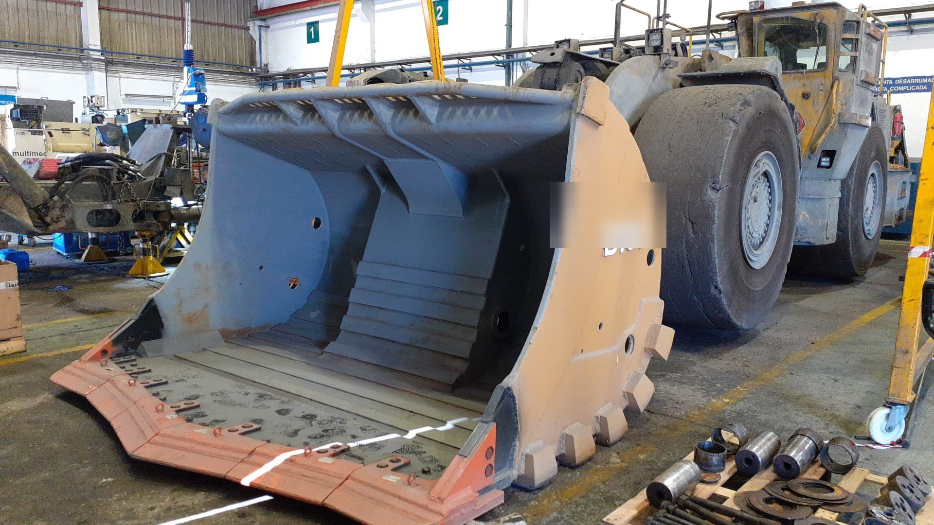 Cazo de equipo LHD terminado con el blindaje antidesgaste, delante de la máquina en el taller minero